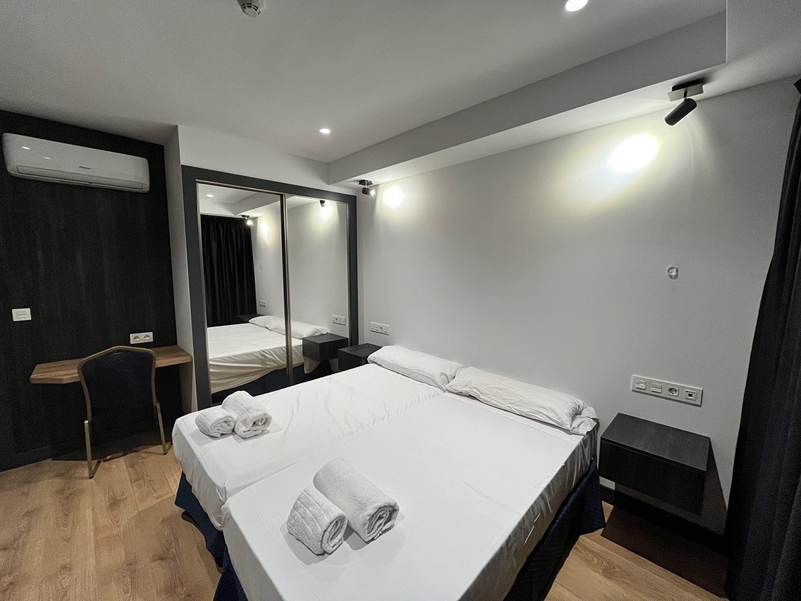 una habitación con dos camas y un escritorio