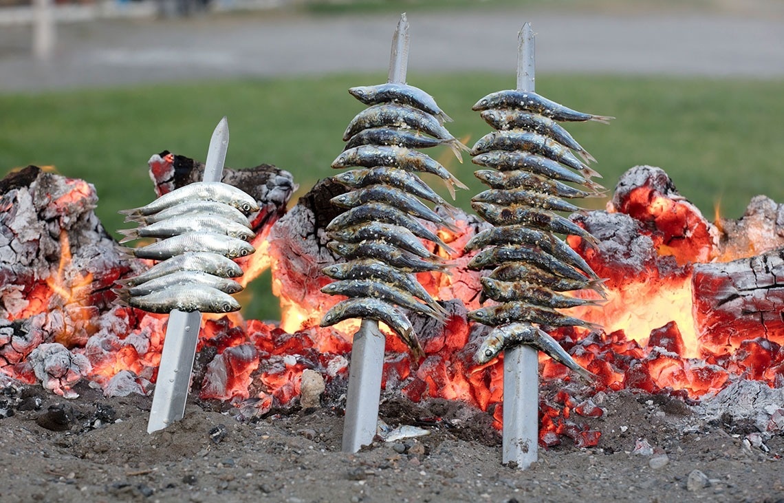 un montón de pescado está asado en un fuego