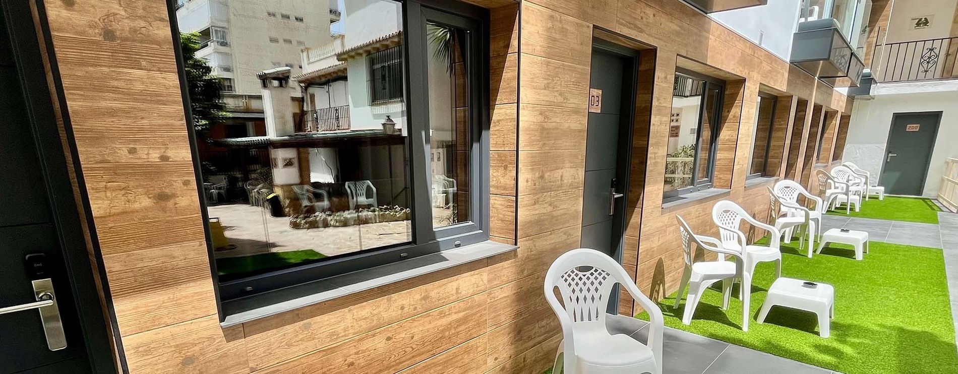 un edificio de madera con sillas y mesas en el patio