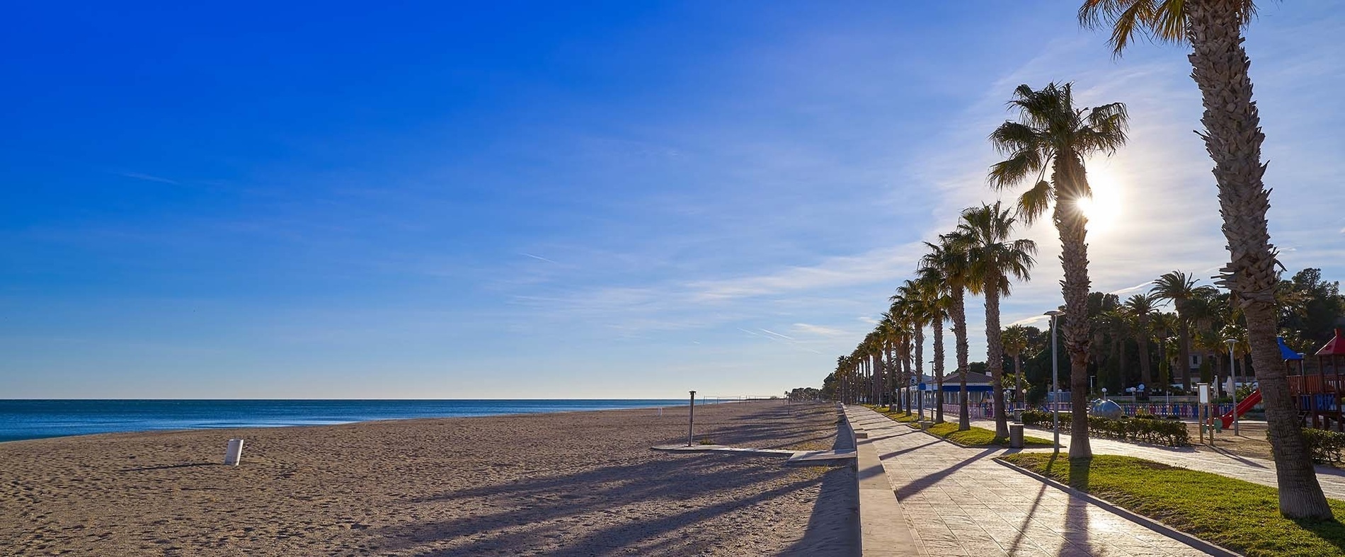 tres mujeres se paran en la playa con los brazos extendidos
