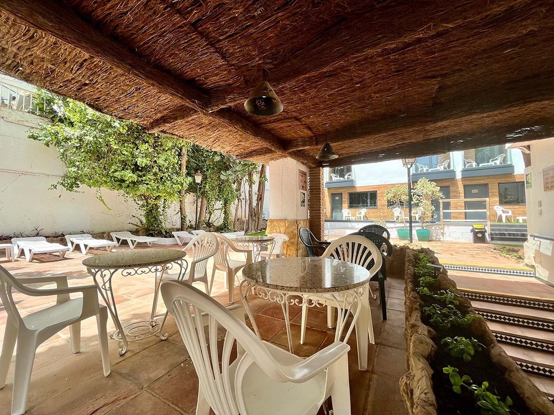 Hotel Villa Albero terrace with tables, chairs, and sun loungers.