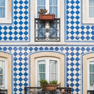 Villa Dorothea: Charming blue and white tiled facade with balconies.