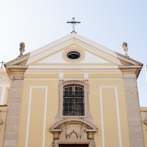 Villa Dorothea: ornate church facade with cross and wrought iron fence.