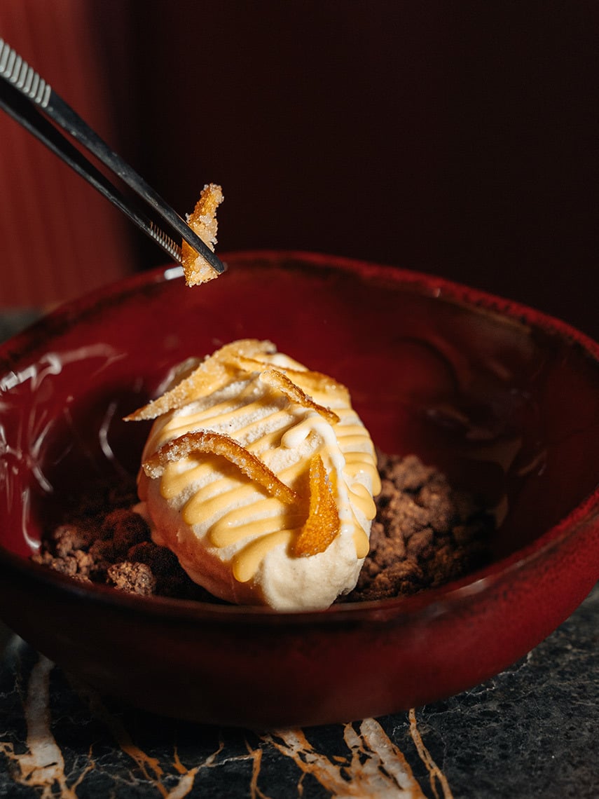 Gourmet dessert being placed into a red bowl, a perfect Villa Dorothea for a fine dining experience.