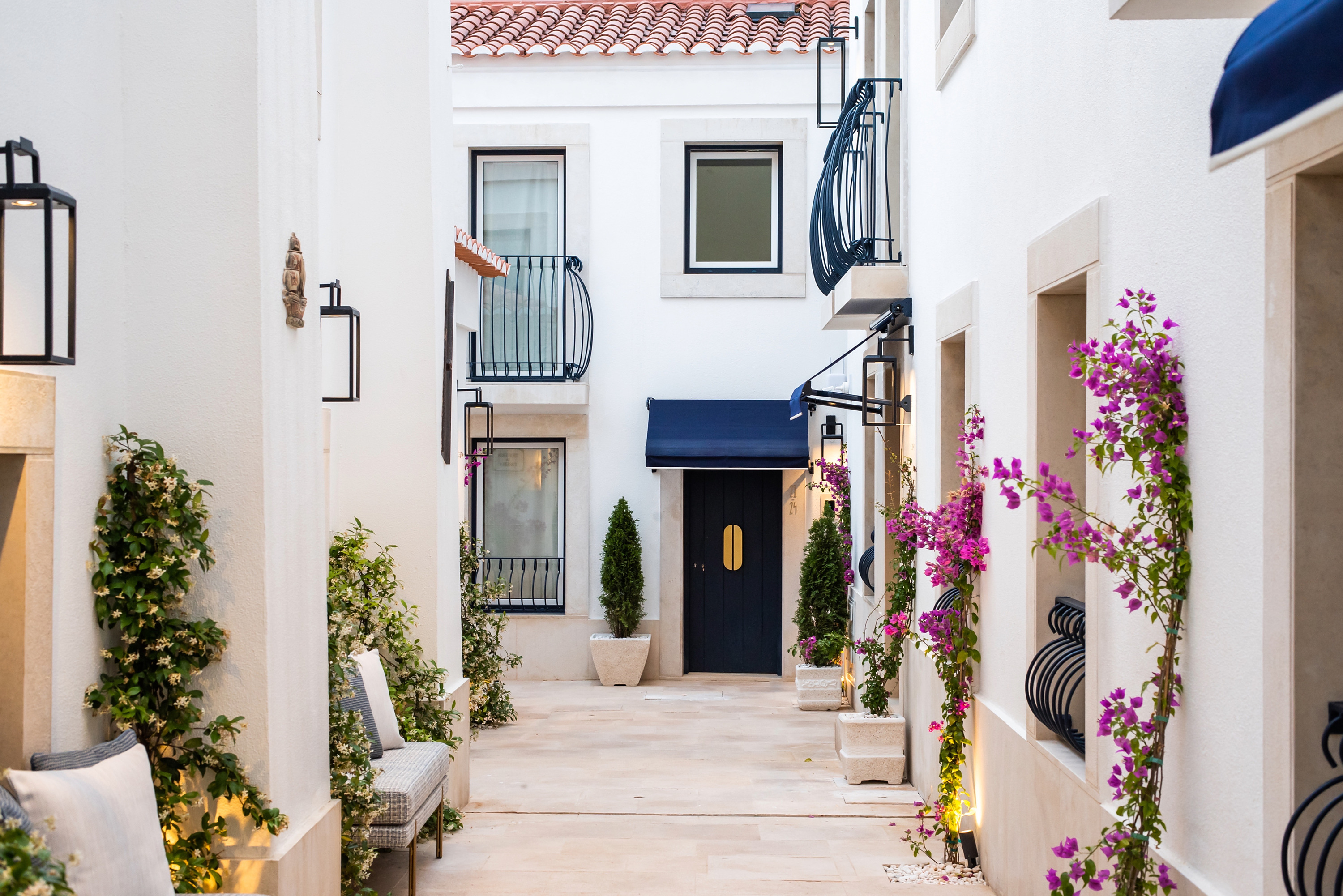 Fachada de Villa Dorothea: puerta azul y toldo, balcón y plantas.