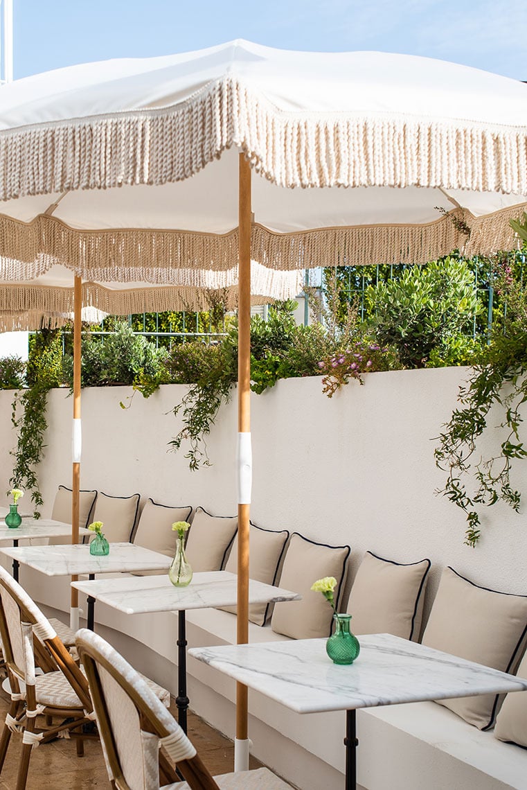 Stylish outdoor cafe seating with umbrellas and marble tables, perfect for Villa Dorothea.