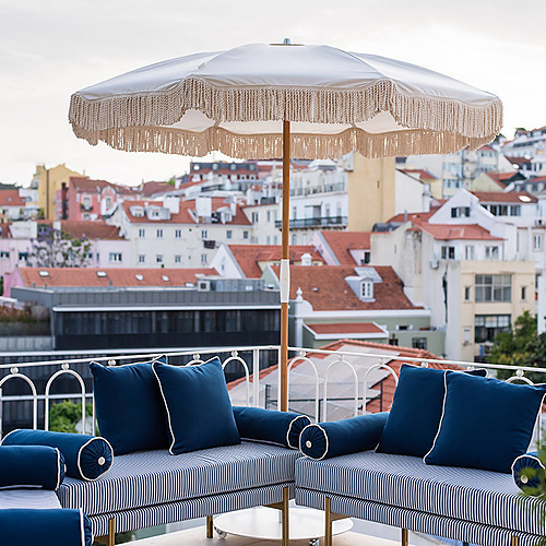 Terraza con vista a Lisboa, Villa Dorothea y sofás de rayas azules y blancos.