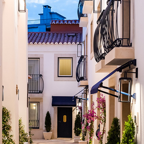 Estancia de lujo en Villa Dorothea: pasillo exterior iluminado con balcónes y plantas.