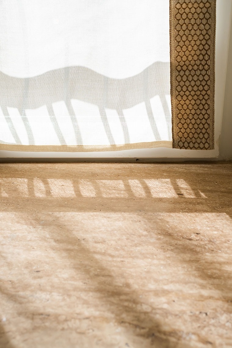 Luz do sol em quarto de hotel: cortinas translúcidas e sombras no piso.