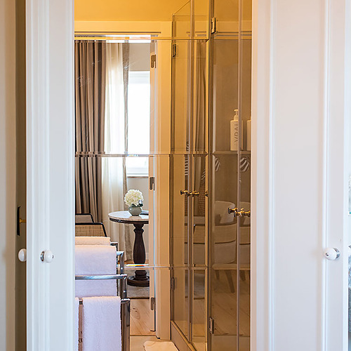 Interior de Villa Dorothea: puerta abierta a baño moderno con toallas y ducha.