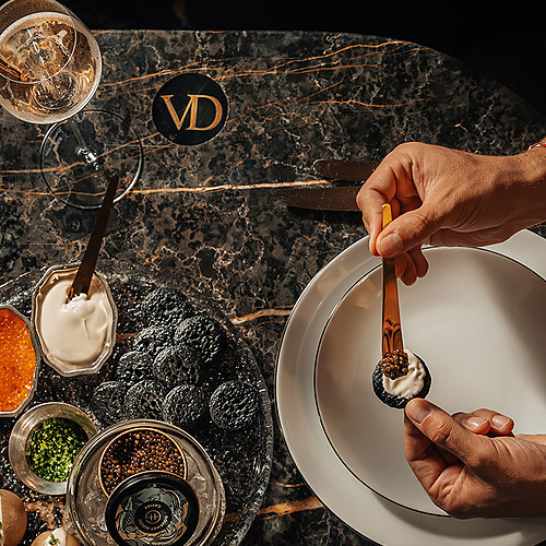 Disfruta de caviar Villa Dorothea premium y una copa de champán en nuestra mesa de mármol.