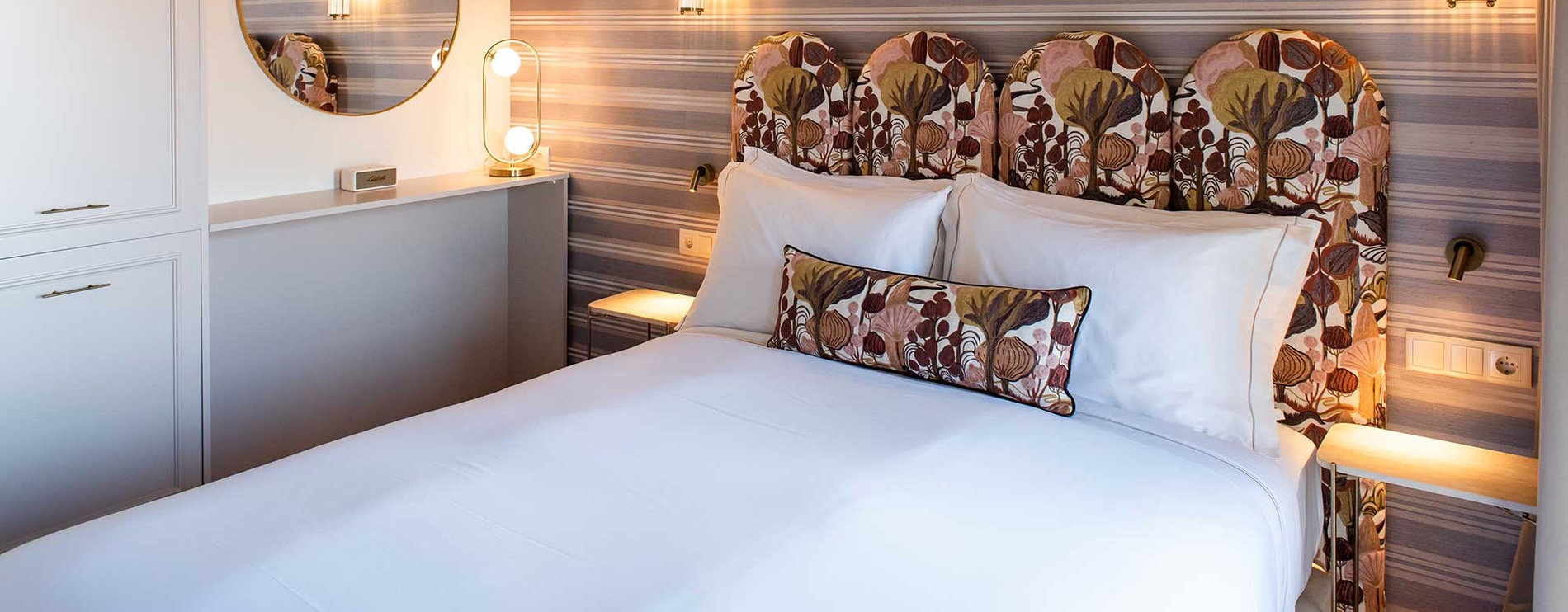 Suite de Villa Dorothea con cama king y cabecero estampado.