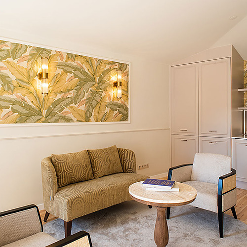 Sala de estar tropical en Villa Dorothea con sillones y sofá.