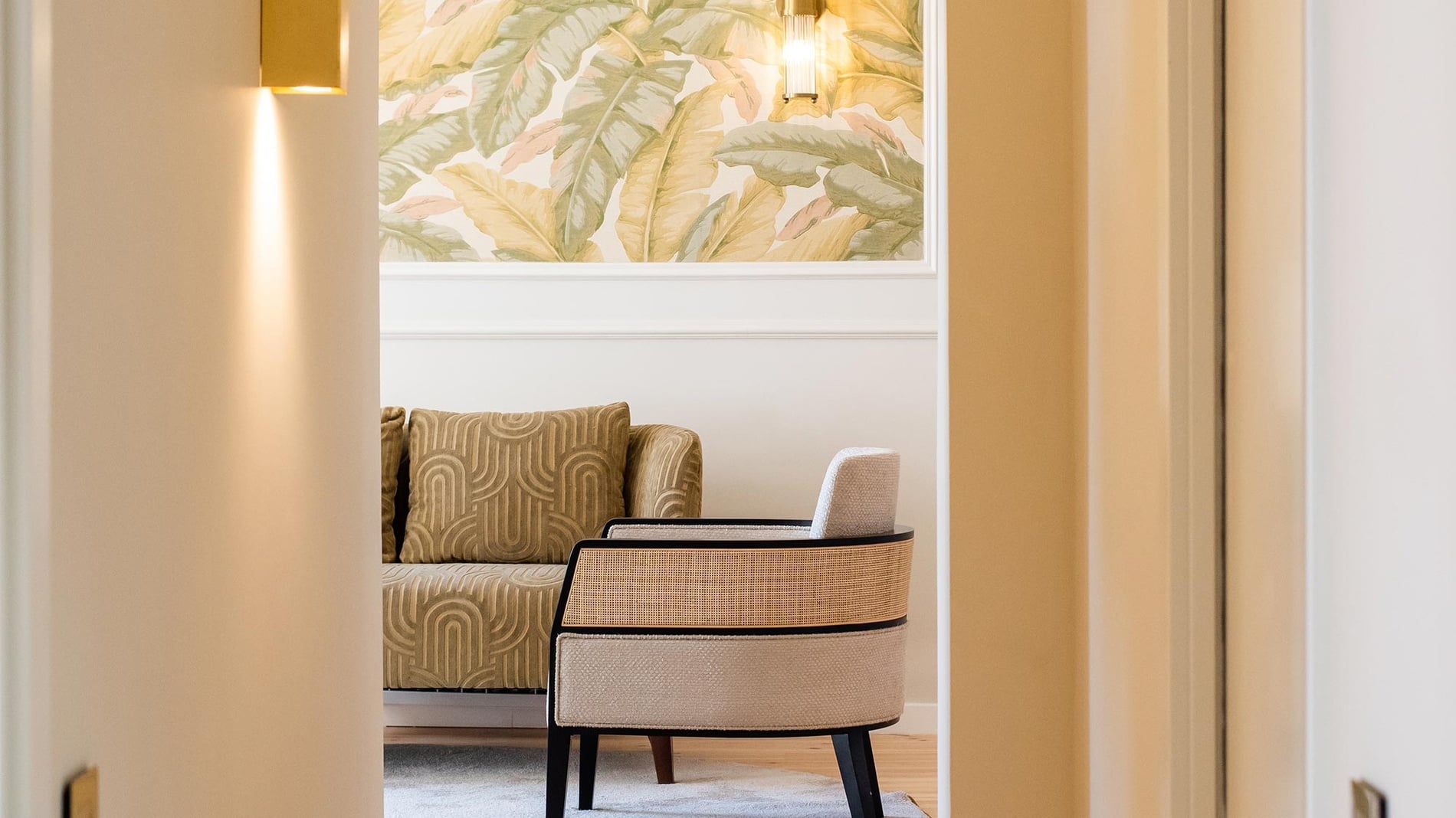 Sofá y sillón de diseño con papel tapiz floral en Villa Dorothea.
