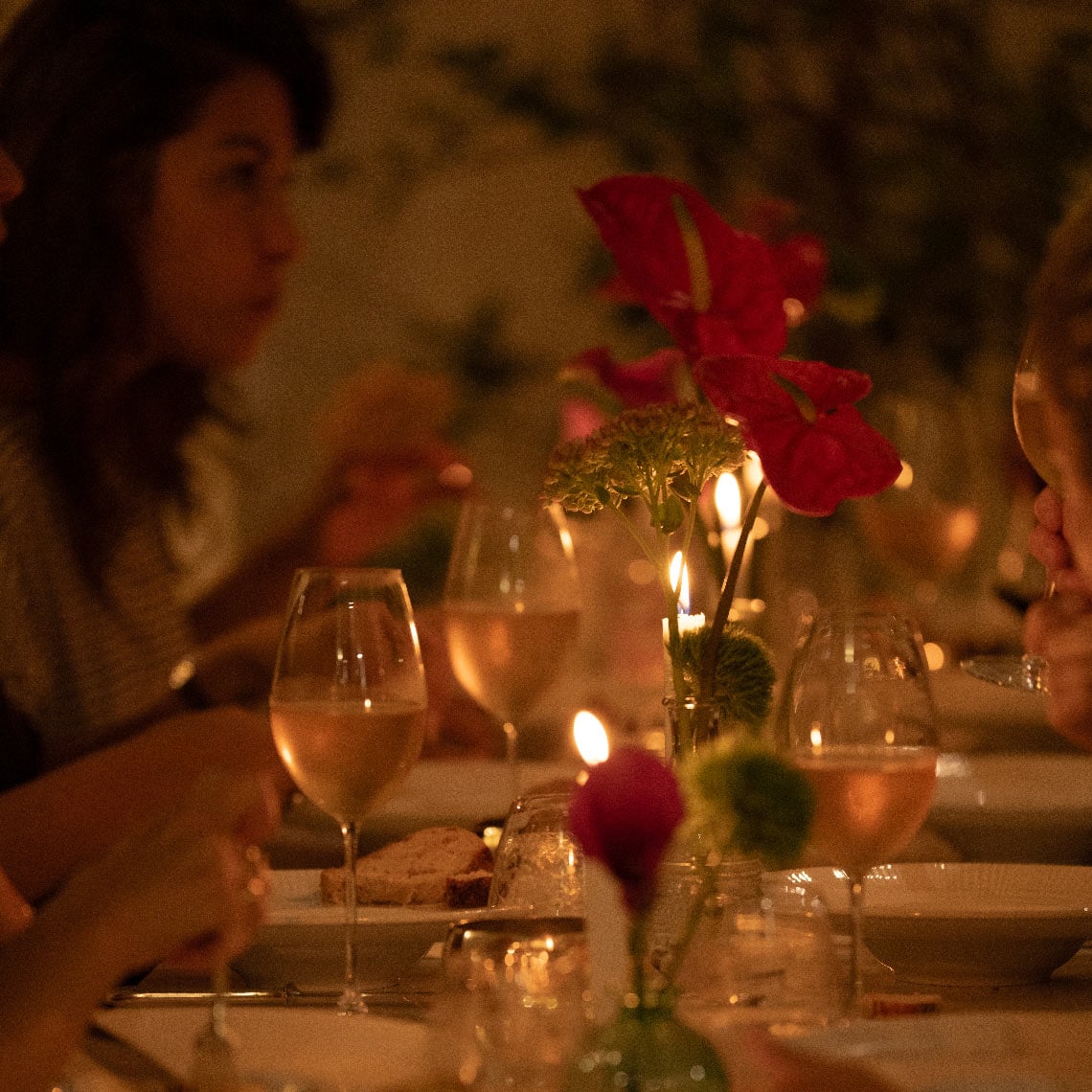 Cena íntima en hotel Villa Dorothea con vino y flores.