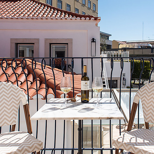 Balcón con vista en Villa Dorothea, con mesa y copas de vino.