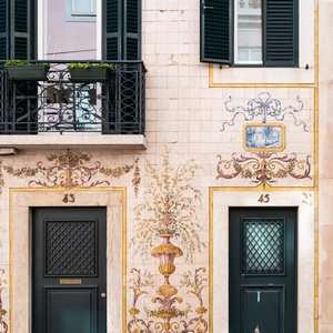 Villa Dorothea: Ornate tiled facade with two dark green doors and traditional shutters.