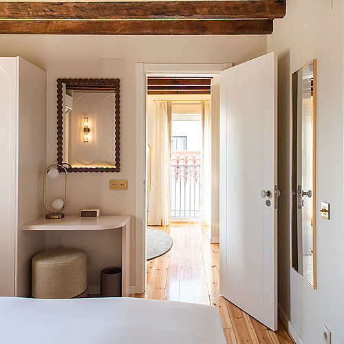 Dormitorio acogedor en Villa Dorothea con armario blanco, espejo decorativo y balcón.