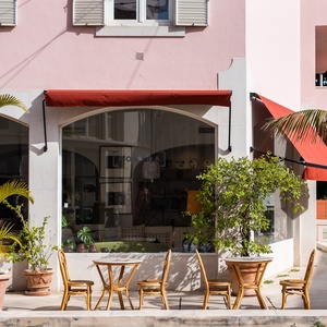 Charming outdoor seating area at Villa Dorothea with palm trees and cafe tables.