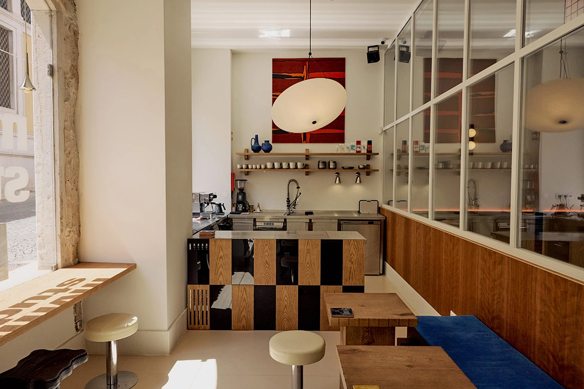 Barra de café moderna con mesas de madera y asientos, ideal para tu Villa Dorothéa.