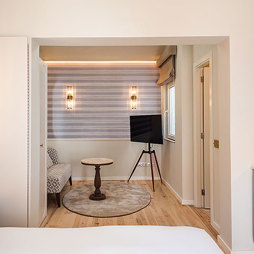 Elegante habitación en Villa Dorothea con TV, sofá y cafetera.