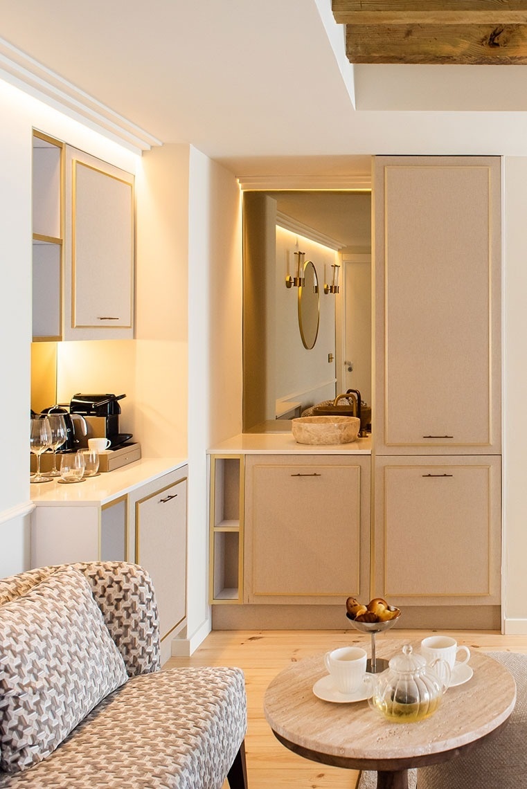 Suite de hotel luxuosa com kitchenette, lavatório, espelho e área de estar. Design moderno e elegante.