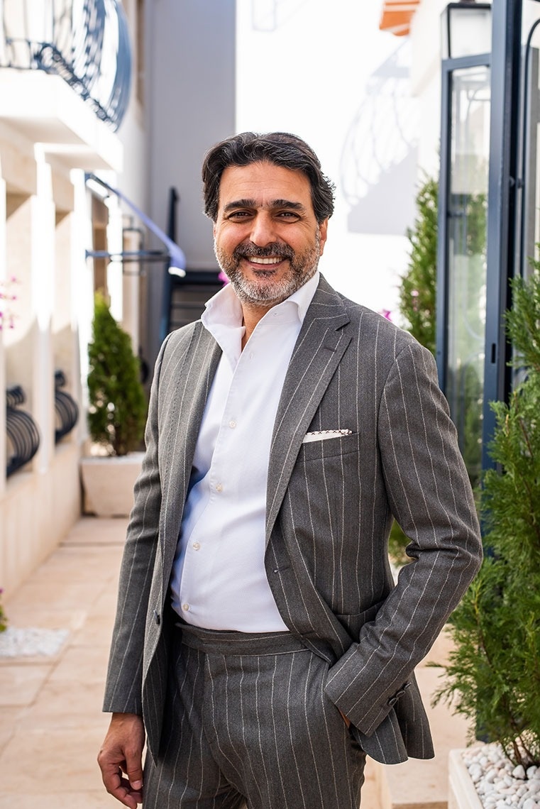 Hombre sonriente y elegante, encarnando la hospitalidad de nuestro hotel.