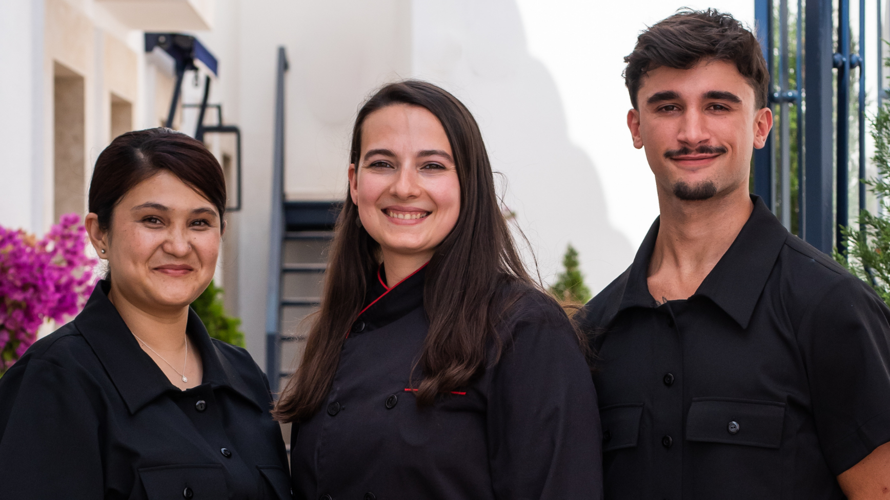 Villa Dorothea staff in black uniforms smiling outside.