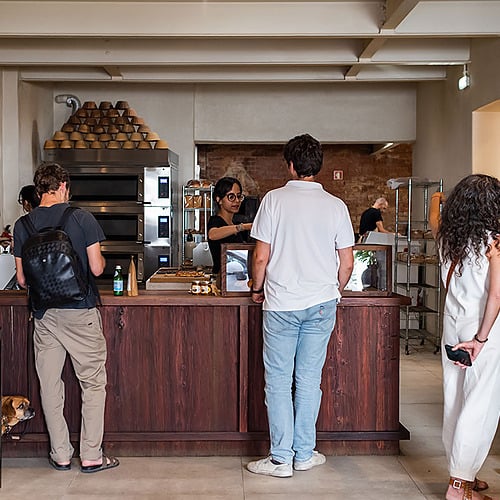 Villa Dorothea: Camarera sirviendo en panadería con clientes esperando.