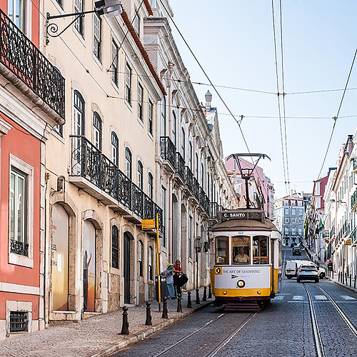 Tranvía amarillo y edificios históricos en Lisboa, ideal para una estancia Villa Dorothea.