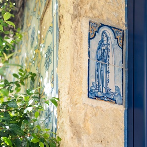 Villa Dorothea: Historic facade features a tiled image of the Virgin Mary and traditional Portuguese tiles.