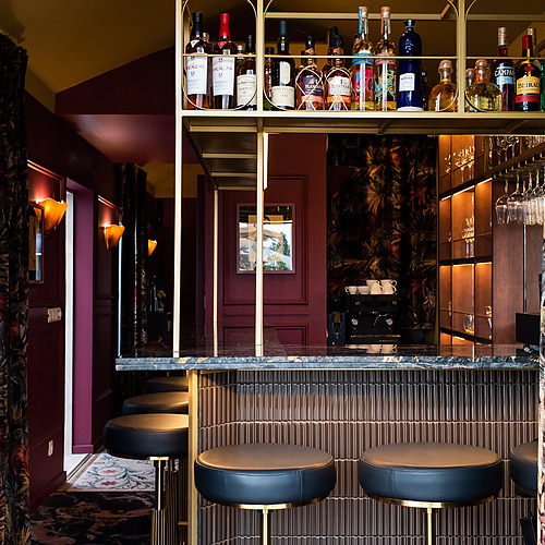 Bar y sala de estar de Villa Dorothea con licores y asientos elegantes.