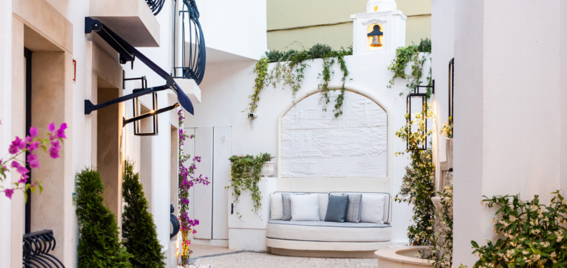 Charming Villa Dorothea entrance with curved seating and greenery.