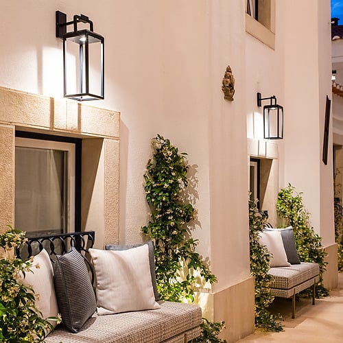 Exterior seating area at Villa Dorothea with ambient lighting and lush greenery.