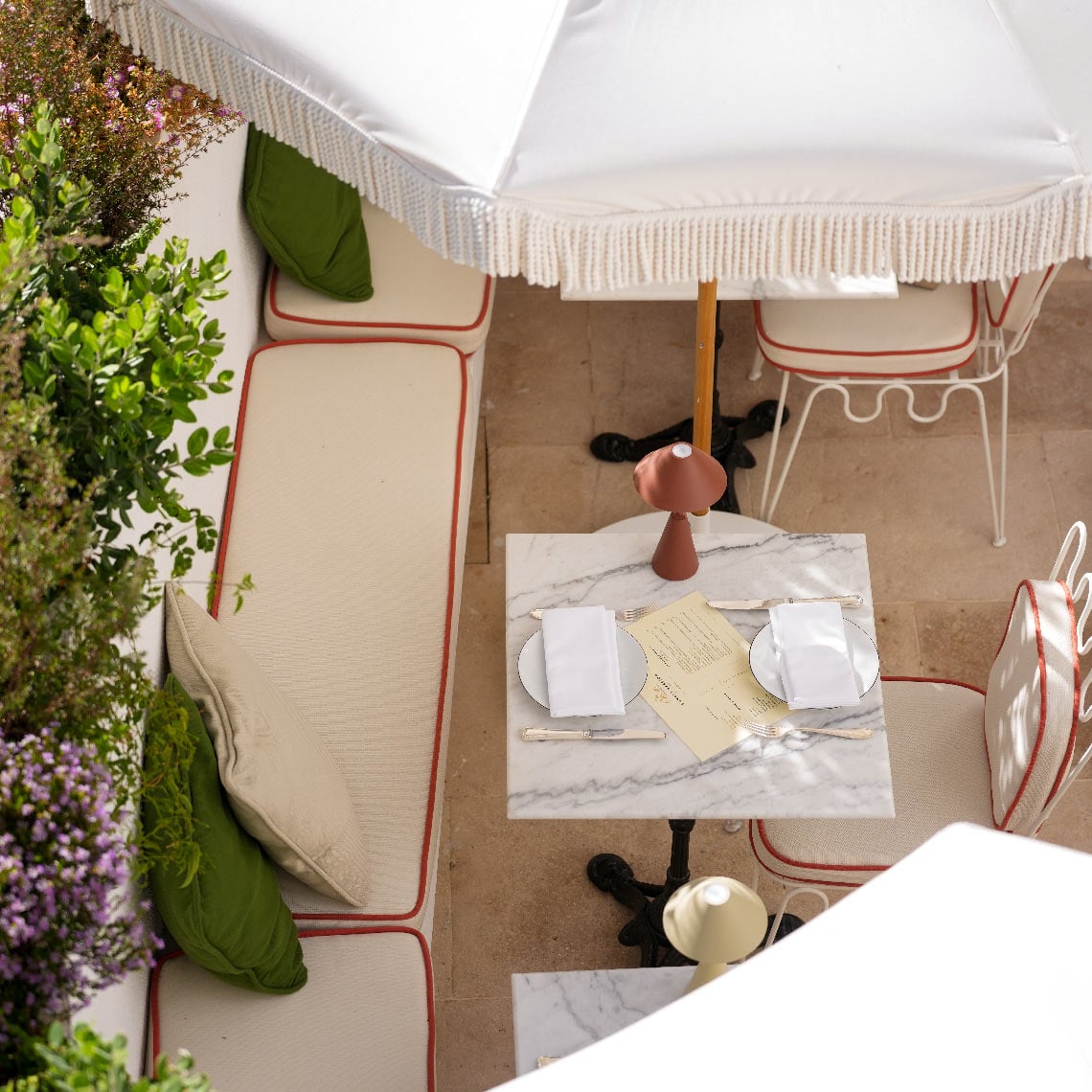 Villa Dorothea: Mesa al aire libre con asientos, sombrilla, decoración y plantas en hotel.