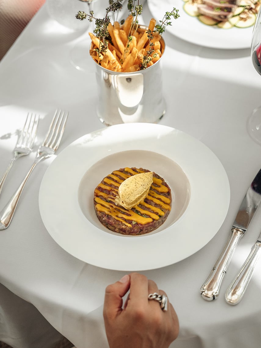 Gourmet dining at a hotel: steak tartare, fries, and wine. Villa Dorothea