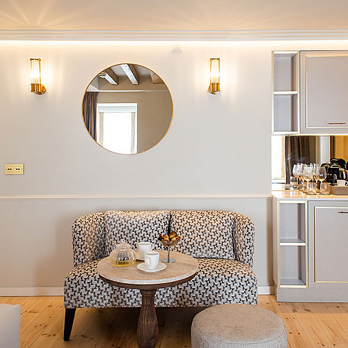 Acogedor salón de Villa Dorothea con sofá estampado, mesa de centro y minibar.