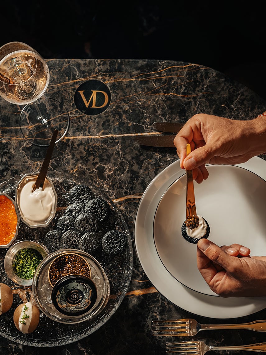 Gourmet dining experience with caviar Villa Dorothea, champagne, and elegant presentation.