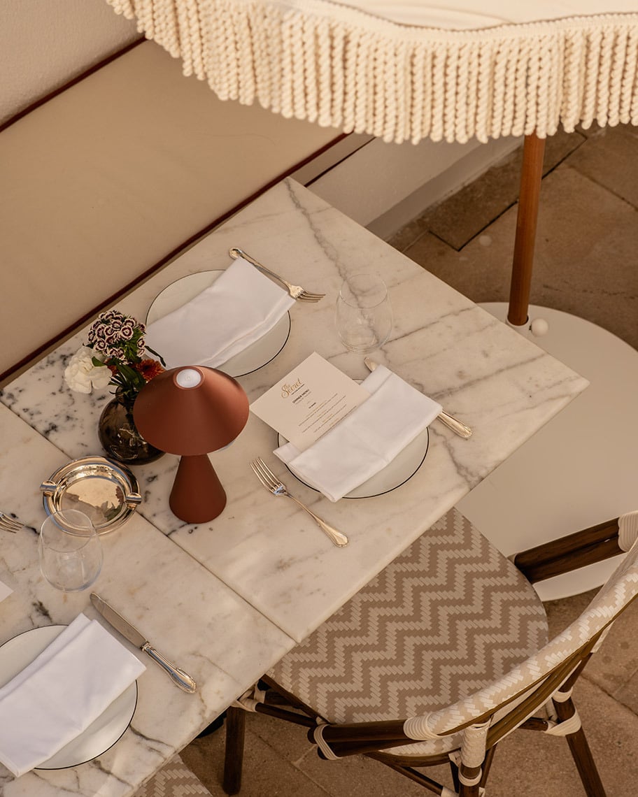 Elegant outdoor dining table setting with a menu and flowers. Villa Dorothea