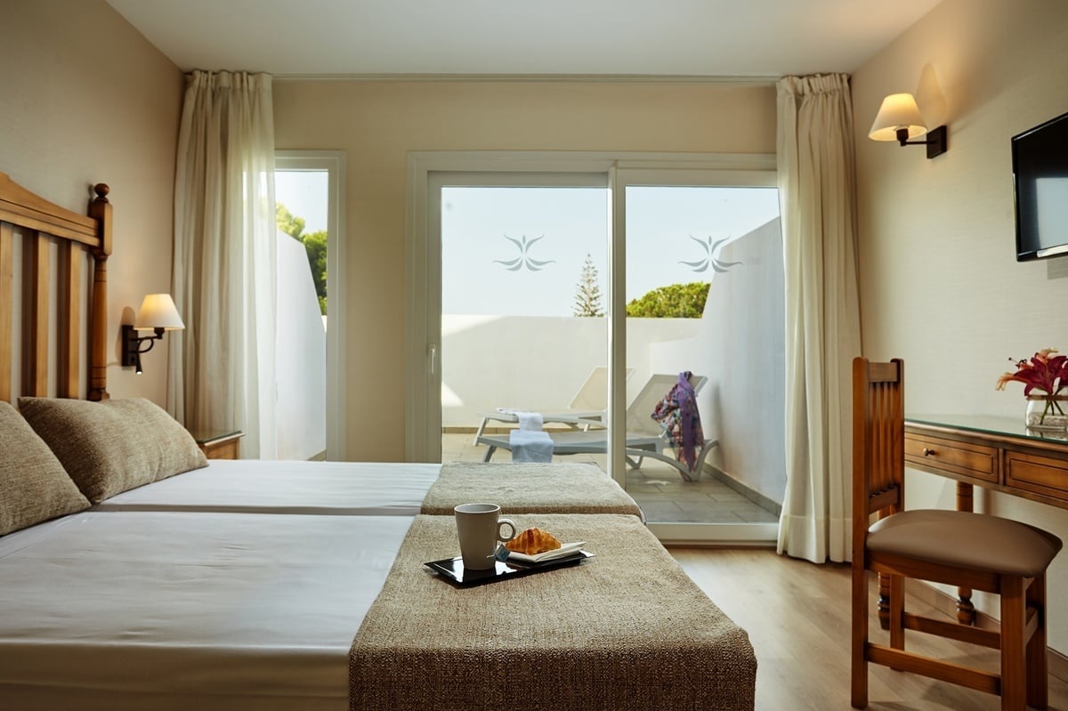 a hotel room with three beds and a mirror