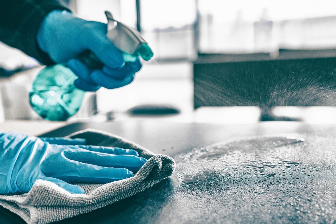 una persona con guantes azules está limpiando una superficie con una toalla