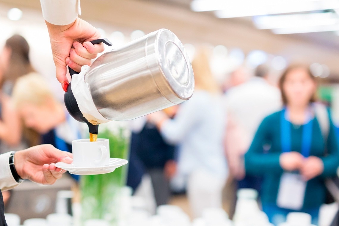 un grupo de personas se sienta alrededor de una mesa mirando una pantalla blanca