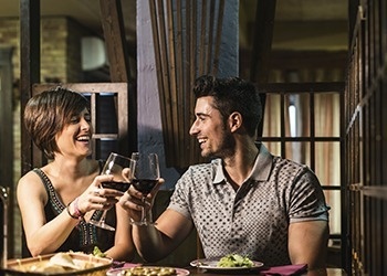 un hombre y una mujer están brindando con vino en un restaurante .