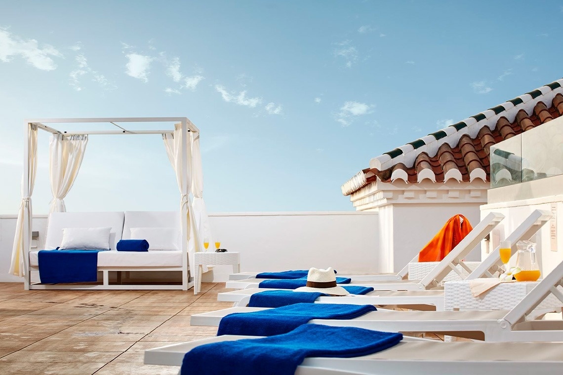 una terraza con sillas y una cama con dosel