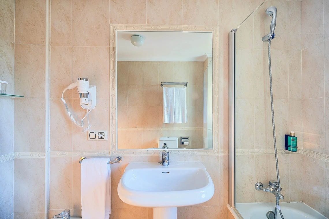 un baño con un lavabo y un secador de pelo