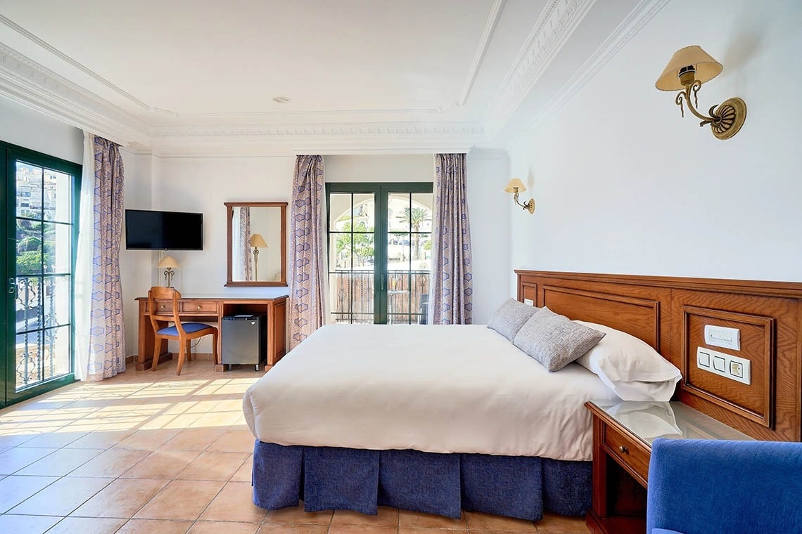 una habitación de hotel con una cama y un escritorio