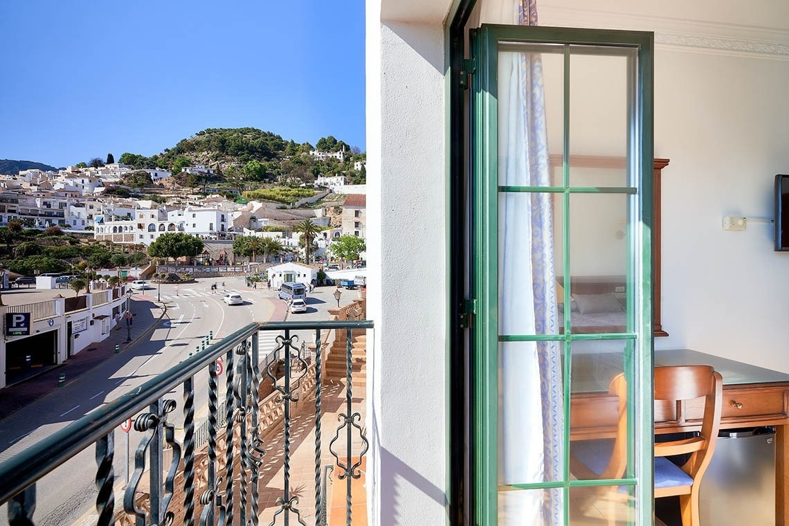 una vista de una ciudad desde un balcón con una puerta abierta