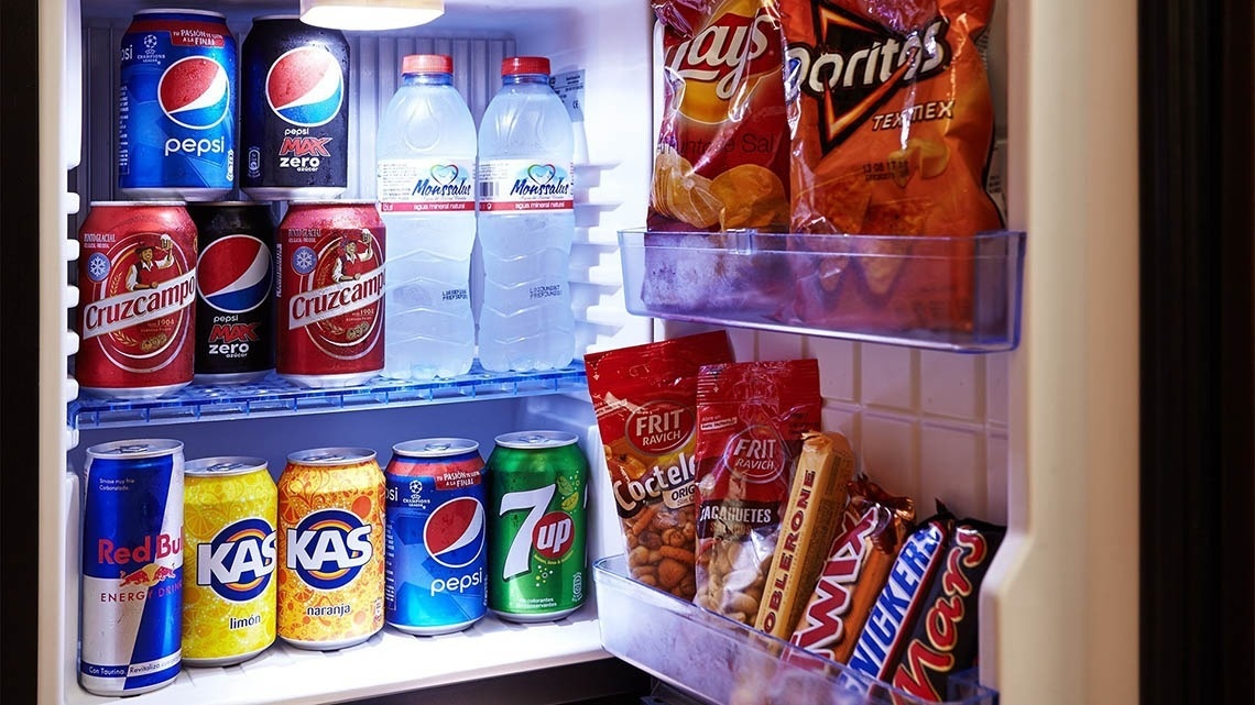 un refrigerador lleno de varios tipos de bebidas y snacks