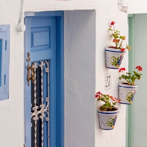 a window with red flowers and a yellow awning