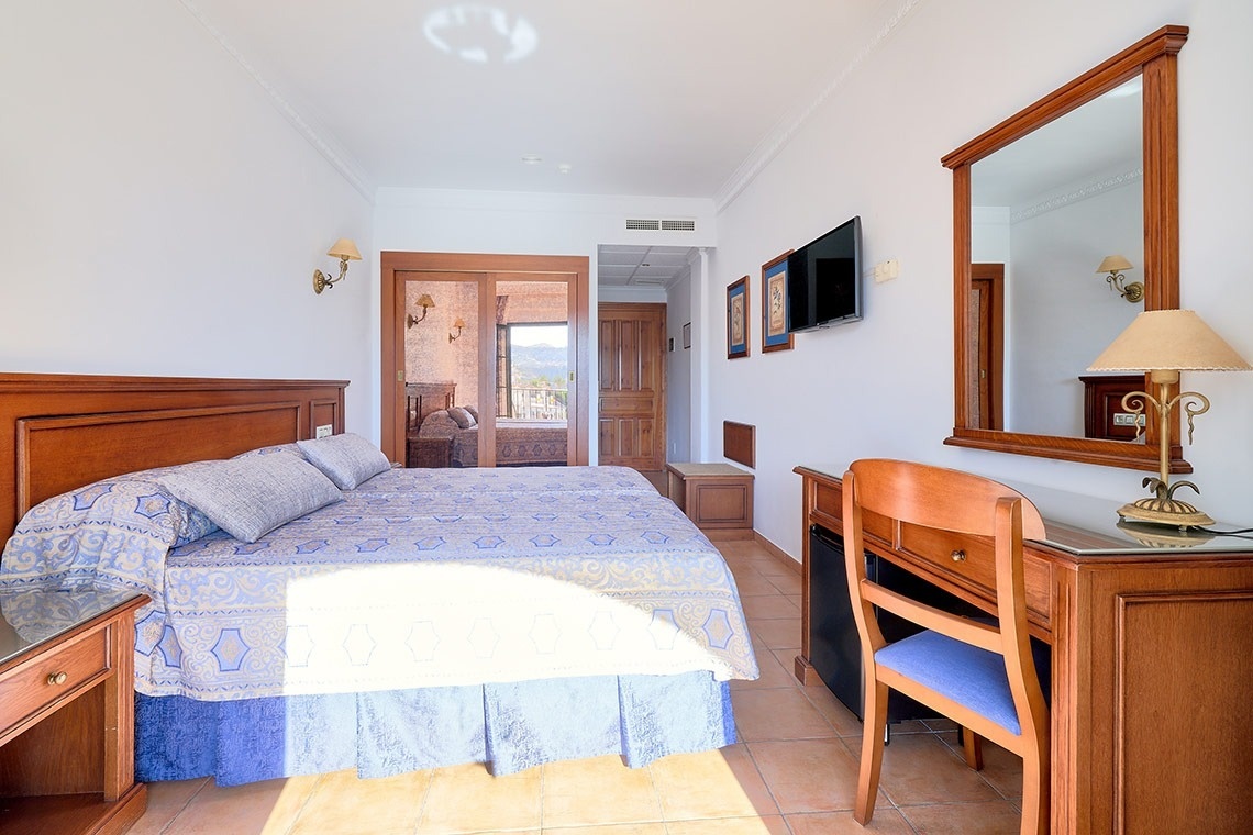 una habitación de hotel con una cama y un escritorio